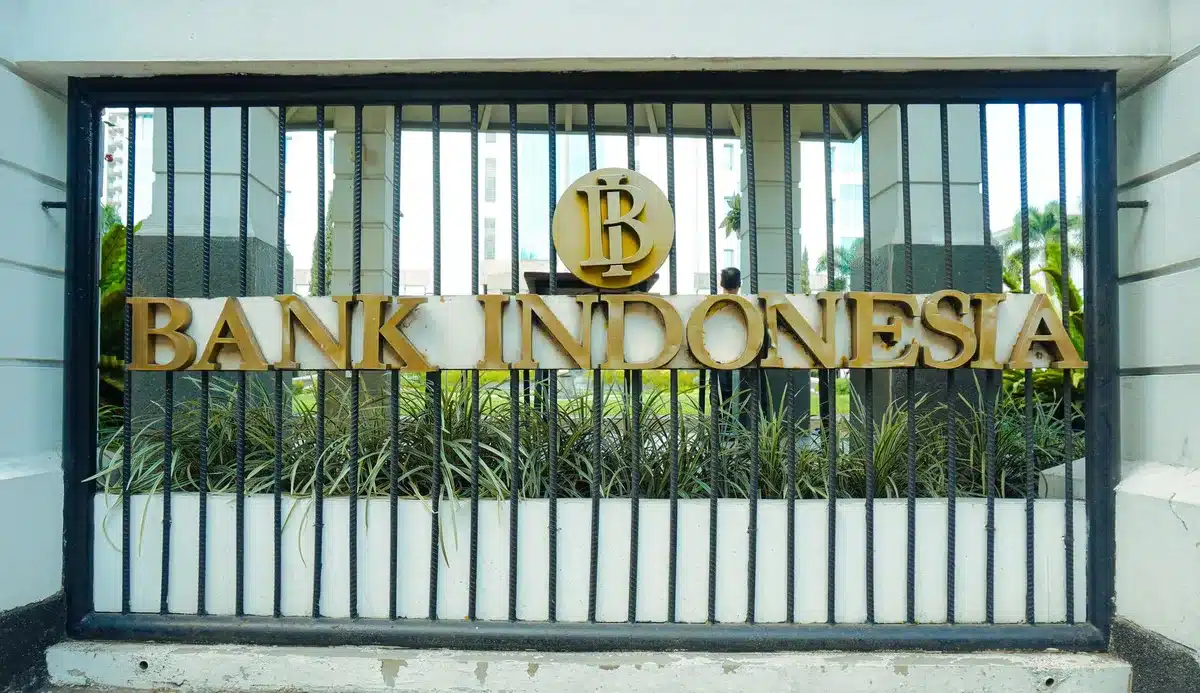 An empty modern bank branch interior with a lone service counter and digital screens, no logos or branding visible