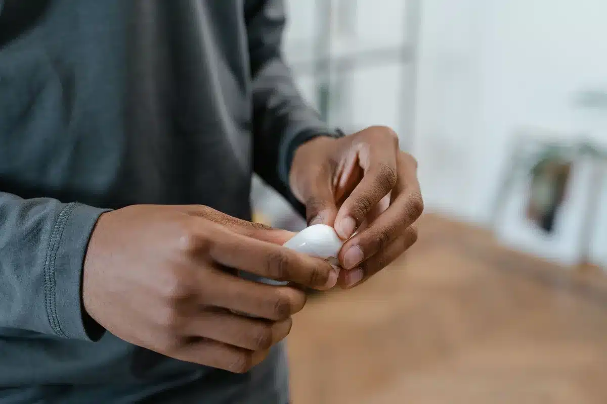 compact earbuds on a neutral surface with an open charging case, no brand visible