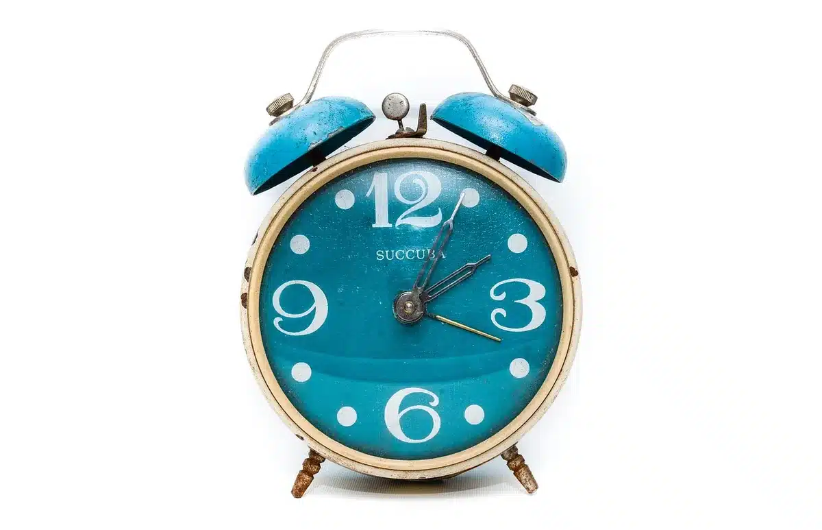 Close-up of an unbranded vintage clock face showing multiple hands and reflections; no people
