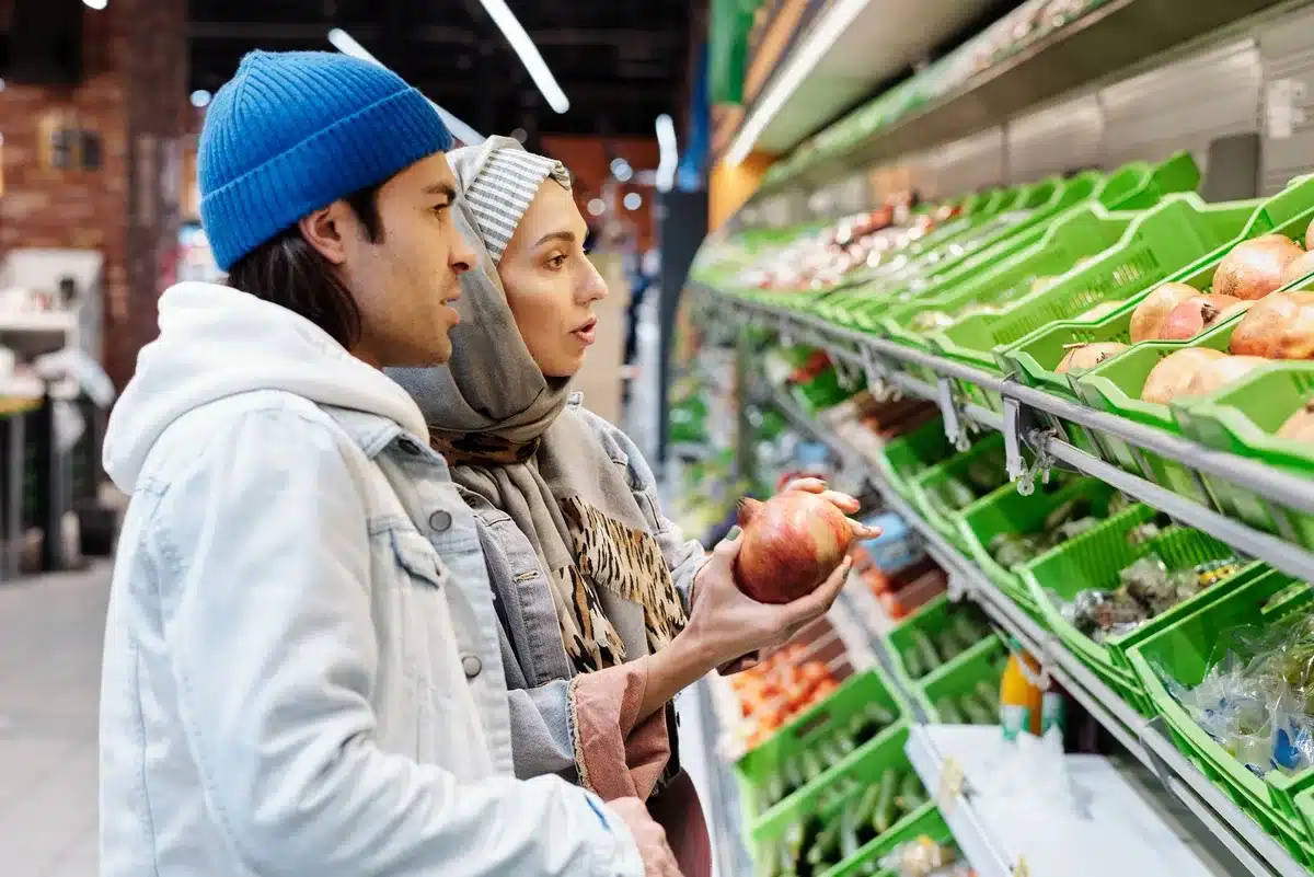 anonymous empty supermarket produce aisle with stacked crates, bright price cards on shelves, no brand visible
