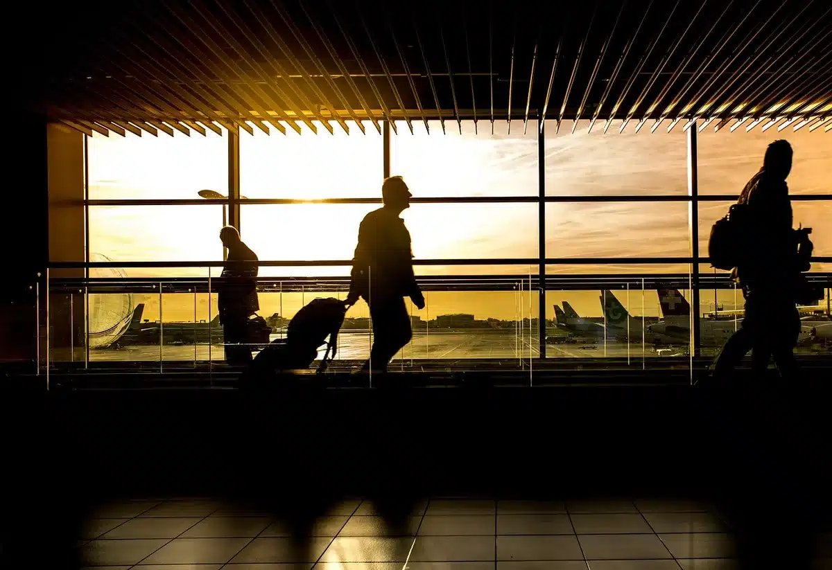 Cola en control migratorio de aeropuerto con pasajeros mostrando pasaportes
