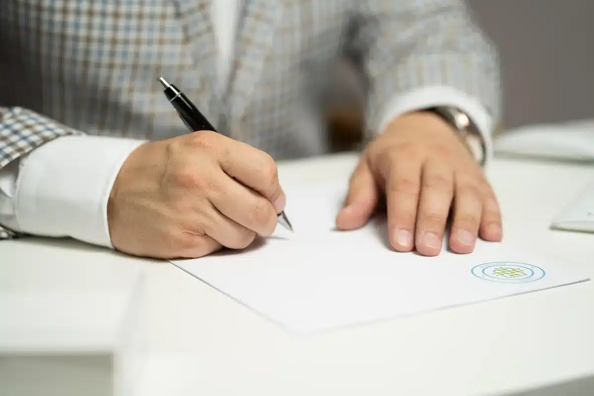 Close-up of an anonymous smartphone on a wooden table showing a camera viewfinder framing a document page; no logos or readable text